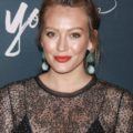 prom updos: hilary duff on the red carpet with her blonde hair in a high ballerina bun wearing a black lace outfit