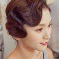 asian woman with her brunette hair in a vintage inspired finger curls updo