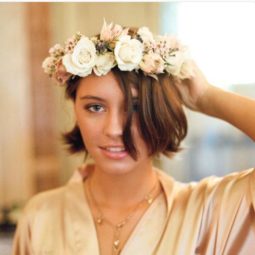 Front view of Iris Law with bob length medium tones brown hair with flower crown headband
