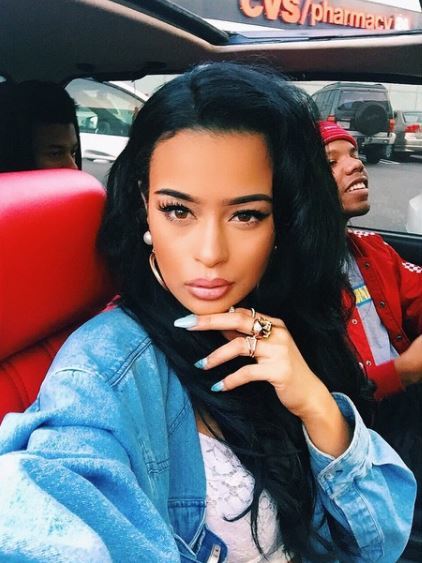 Rainy Milo wears her black long hair in side parting with loose hollywood waves in car with male friend