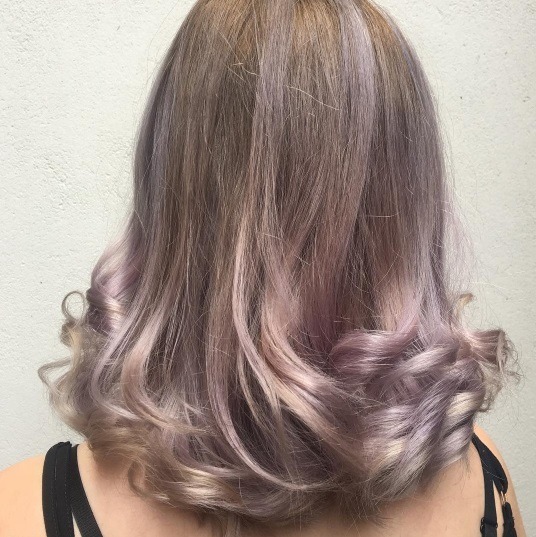 back shot of a woman with brown hair with lilac balayage highlights