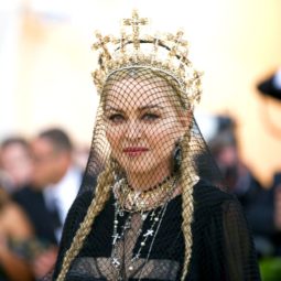 Madonna hair: Madonna at the 2018 Met Gala with her blonde hair in two pigtail braids with a black veil and gold crown.