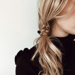 woman with messy staircase side braided ponytail hairstyle