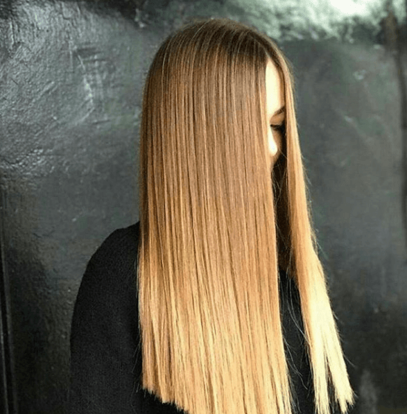 model with very long hair with brown to blonde ombre finish in poker straight style
