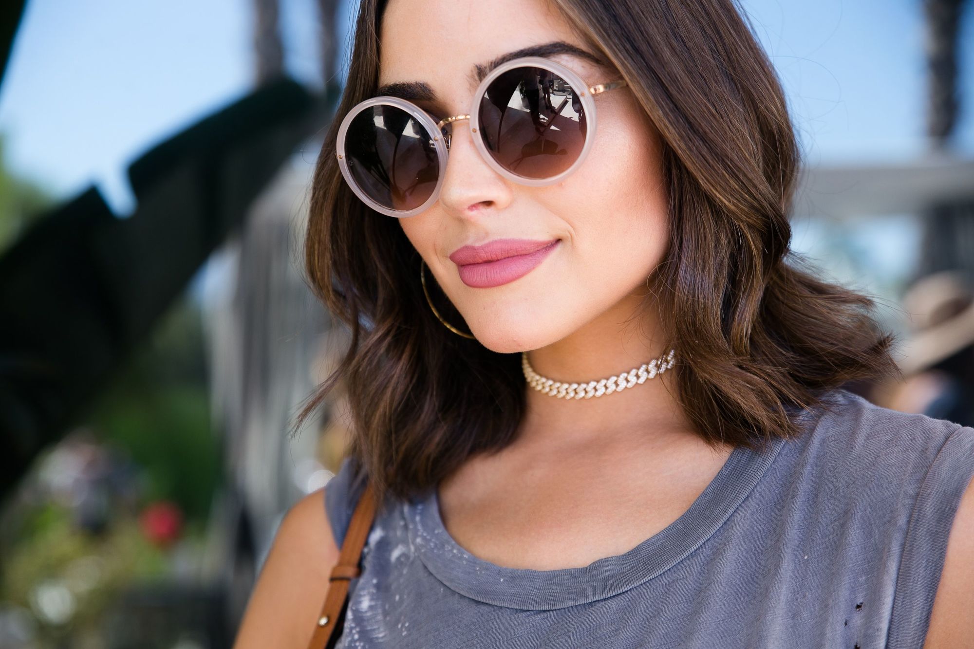 medium bob hairstyles: olivia culpo with short wavy bob hairstyle wearing sunglasses and smiling