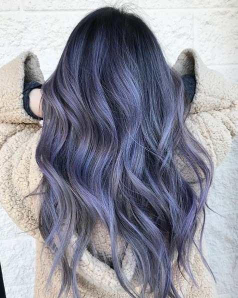 Balayage long hair: Back view of a woman with long curly purple balayage hair