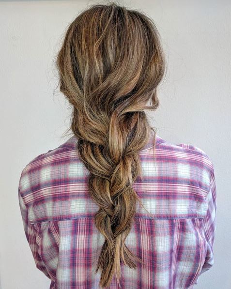 The back view of a brunette model with a very loose traditional plait