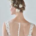 backshot of model with milkmaid braided hairstyle updo with flowers