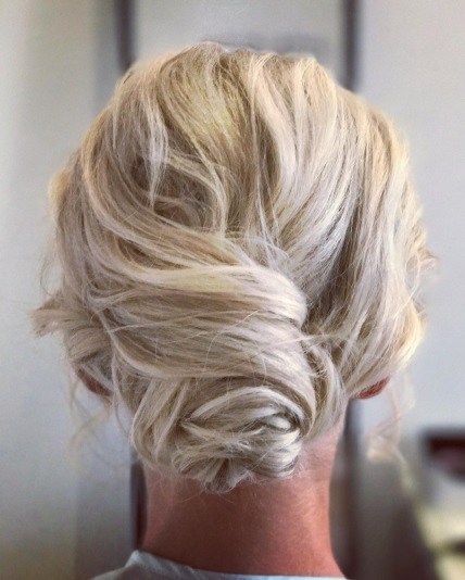 woman with ice blonde hair in a dishevelled low bun