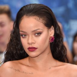 Rihanna with slicked back strands wearing red on the Valerian red carpet