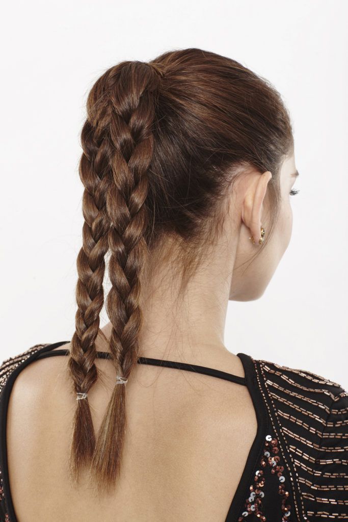back view of a woman with two braided ponytails in brunette hair