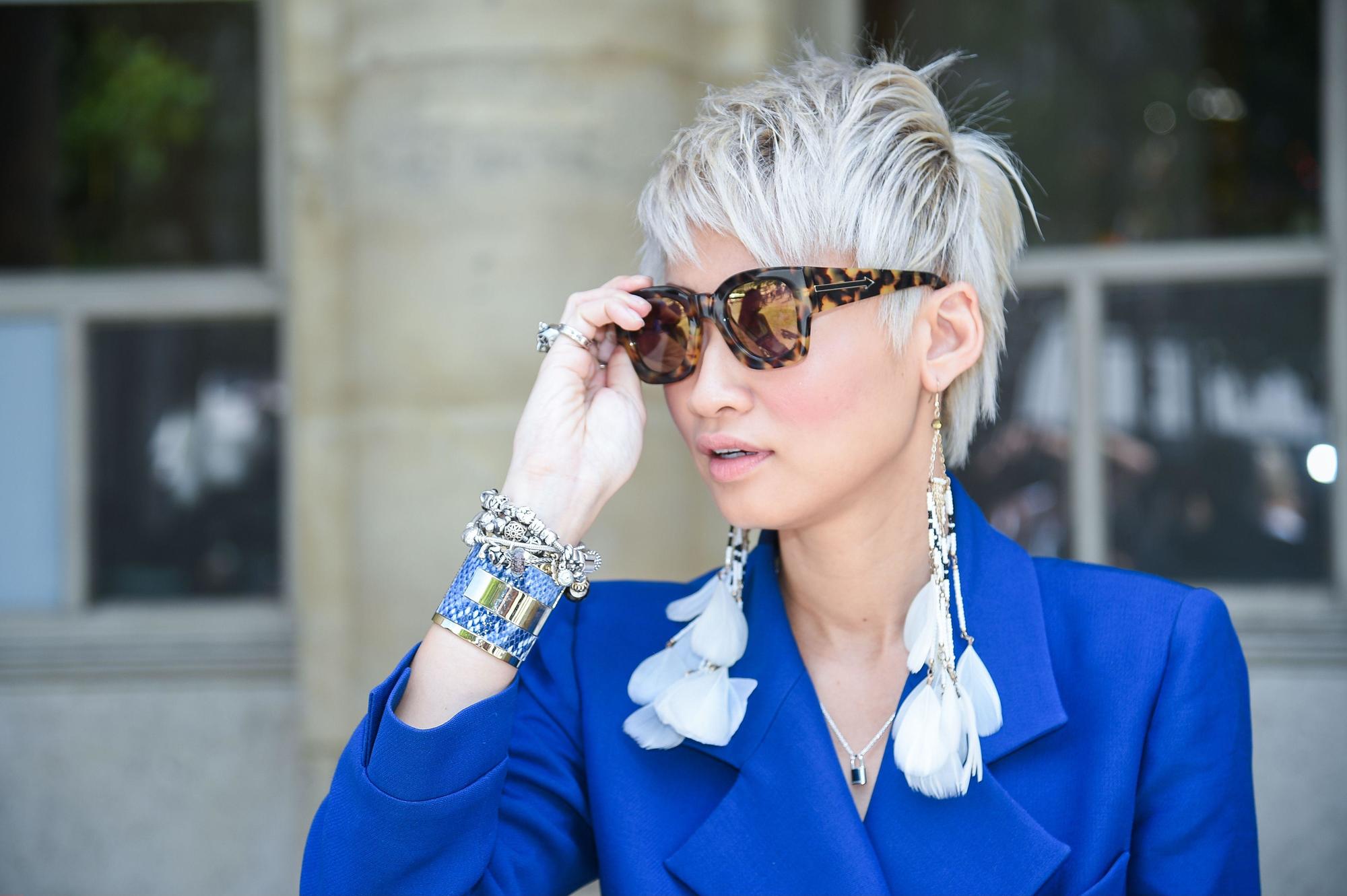 Purple conditioner for blonde hair: Street style model with short hair and a long fringe hairstyle, wearing sunglasses and blue jacket
