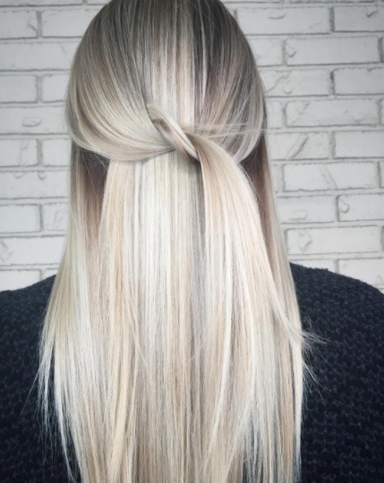 Balayage long hair: Back view of a woman with long straight silver blonde balayage hair