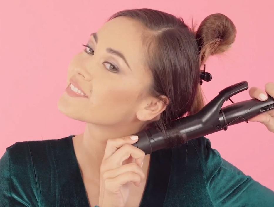 shot of brunette model curling her hair