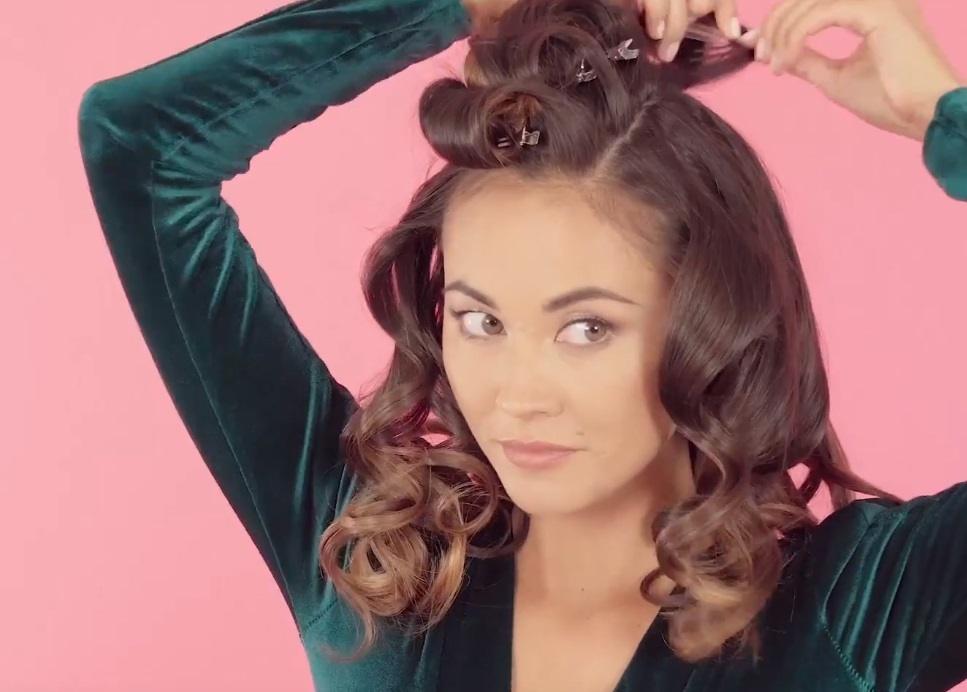 a woman undoing curls on her hair