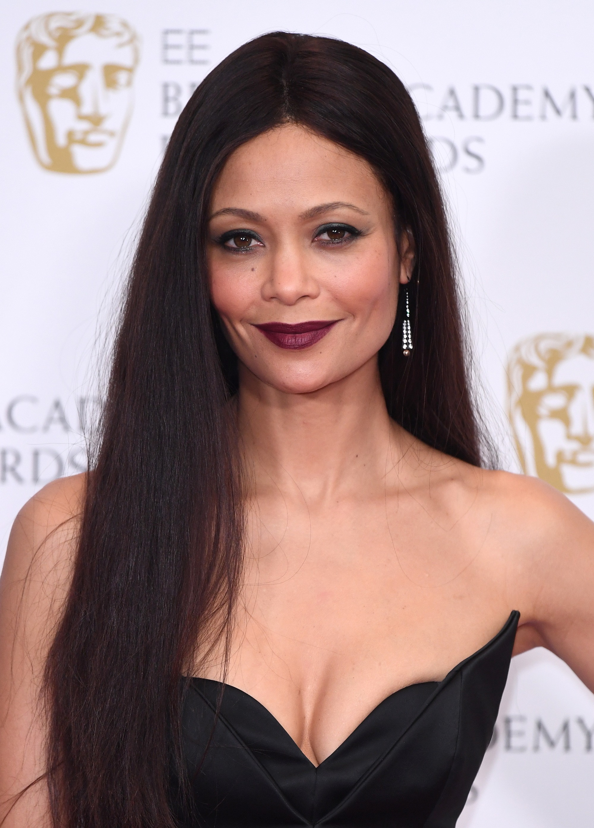 thandie newton with cherry dark brown hair on the bafta's red carpet wearing plum lipstick and black dress