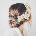 Dark blonde hair in chignon style with pastel coloured flowers for wedding style