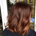 back view of a woman with sunkissed auburn highlighted hair