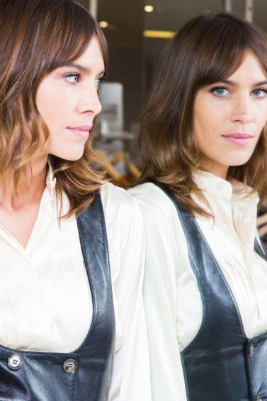 the best bangs directory: close up shot of alexa chung with bardot bangs hairstyle staring into the mirror