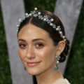 close up shot of emmy rossum with braided low bun and pearls in her hair on the red carpet