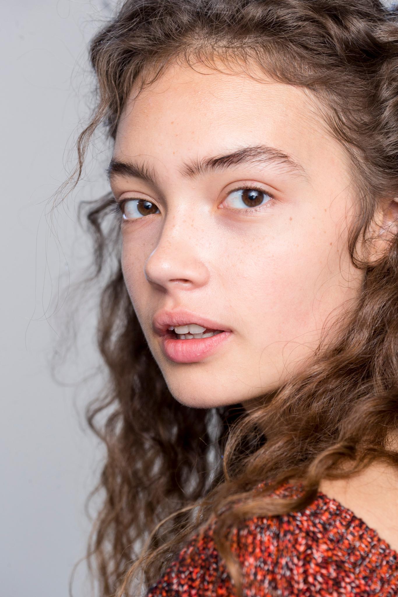 close up shot of woman with thick curly hair backstage at a show