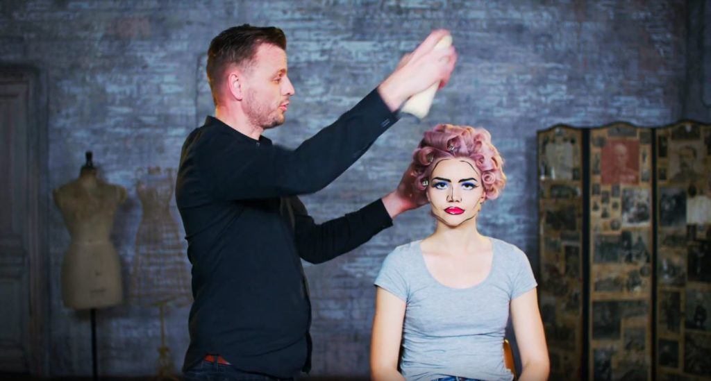 Superdrug Loves cartoon kid Halloween hair tutorial whole head of pin curls being sprayed with hairspray