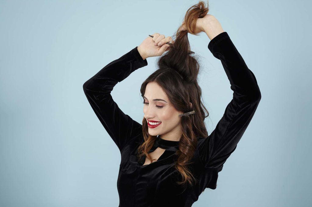 Curly ponytail tutorial: Brunette model teasing her hair