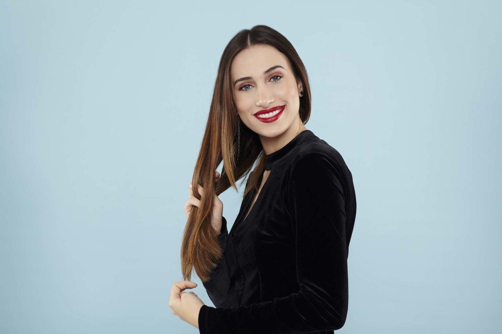 Curly ponytail tutorial: Brunette model putting product in her hair