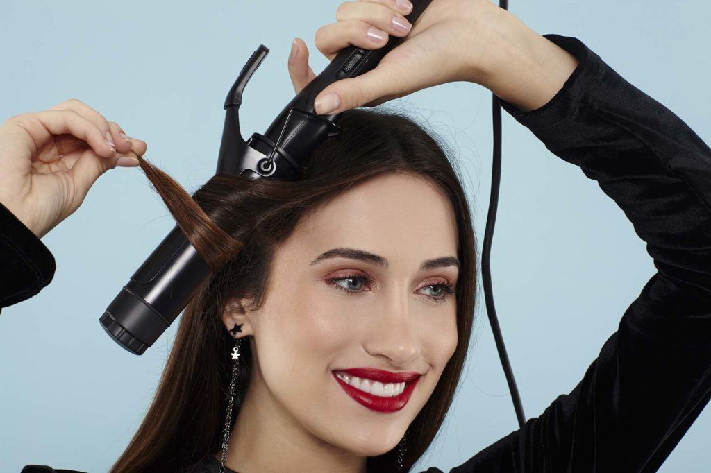 Curly ponytail tutorial: Brunette model curling her hair