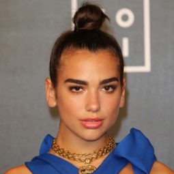singer dua lipa with her dark hair in a top knot style