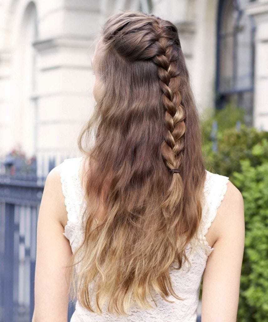 Easy braids for long hair: Back view of a woman with brunette ombre long wavy hair in a half-up braided hairstyle