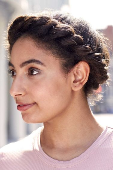 brunette woman with afro hair styled into a flat twist halo braid updo