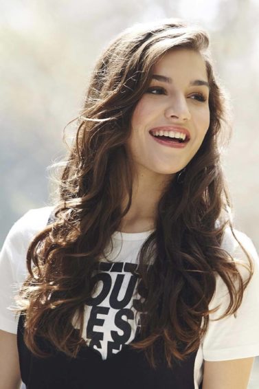 Brunette model laughing outside with heatless curls: