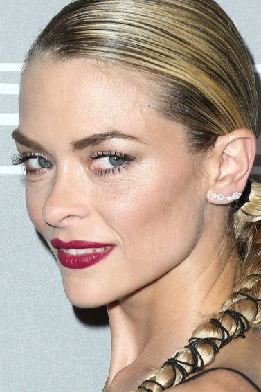 shot of jamie king with party braids that have been wrapped with ribbon, wearing black on the red carpet