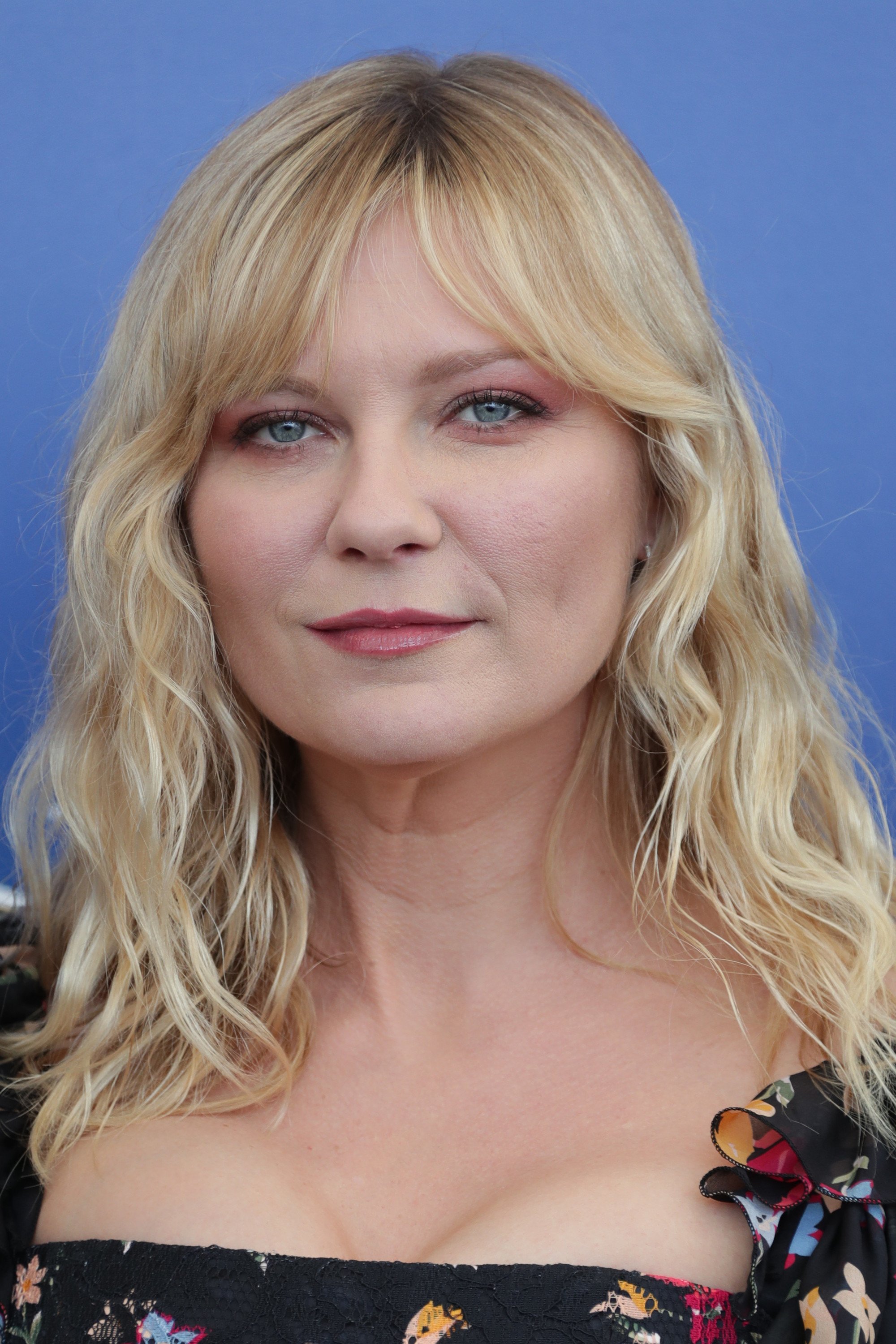 actress kirsten dunst with wavy blonde hair and parted bangs