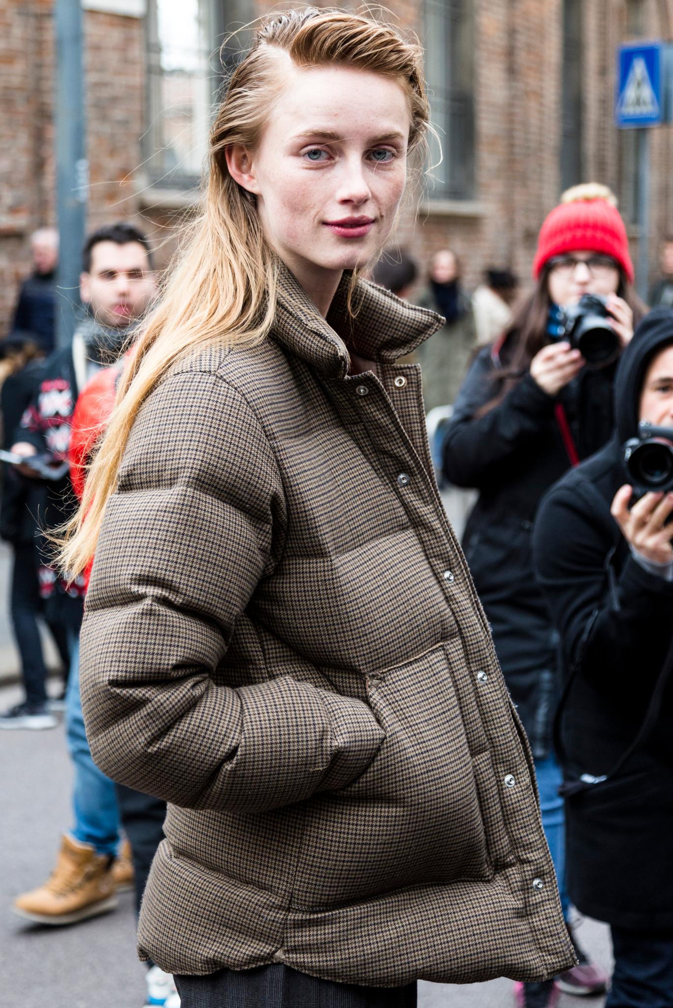 Milan Fashion Week Street Style: Woman with long blonde hair in side parting with soft quiff wearing a puffa jacket.