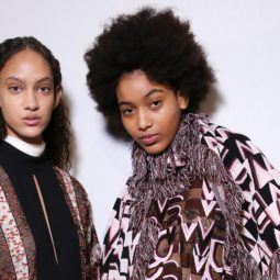 Natural hair textures: Two models backstage with curly hair, one with long spiral curls, the other with a tightly coiled afro
