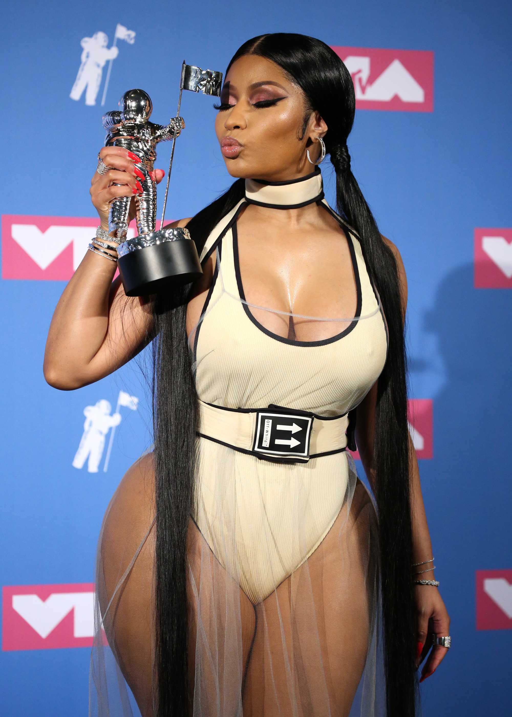 Red carpet hairstyles: Nicki Minaj with long black pigtails, holding an award on the VMA red carpet.