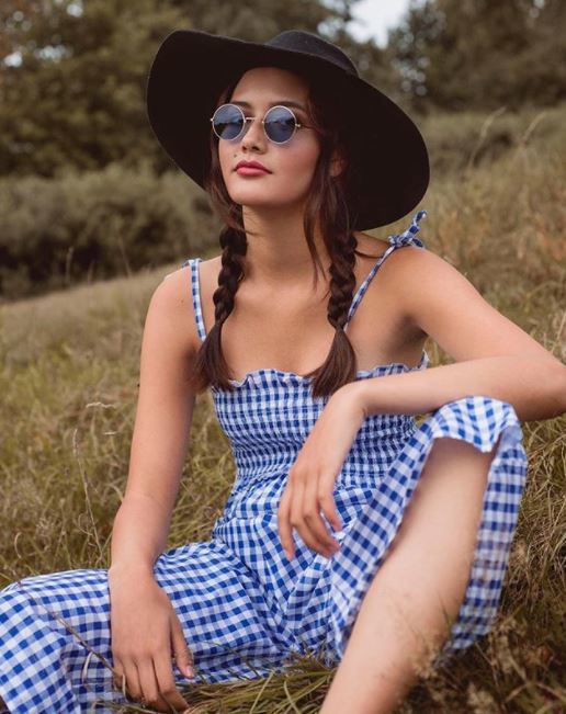 brown medium length hair in pigtail braids with wide brim hat