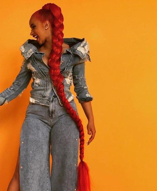 side profile of Cardi B with rapunzel length red hair in ponytail braid