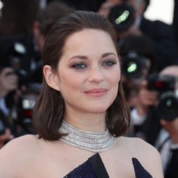 Marion Cotillard with long bob length dark brown hair smoothed back at red carpet premiere with strapless navy dress