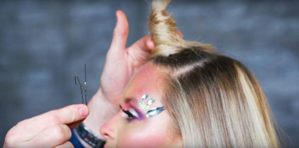 Unicorn Halloween tutorial: Close-up of a blonde model with a unicorn horn inspired hairstyle, wearing sparkly unicorn glitter makeup