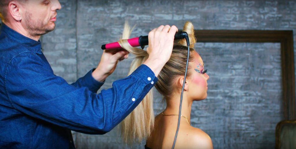 Unicorn Halloween tutorial: Close-up of Unilever hair stylist Dan Lynes using a curling tong to curl a blonde model's ponytail for a Halloween hair look