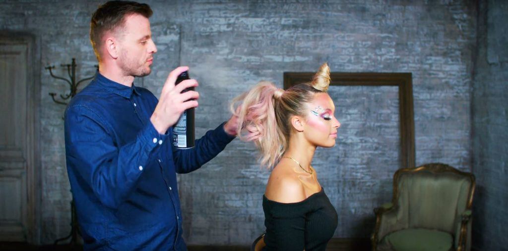 Unicorn Halloween tutorial: Unilever hair stylist Dan Lynes spraying hairspray on a blonde model's unicorn inspired hairstyle
