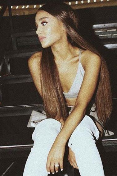 shot of ariana grande with brown hair at concert sitting on steps with long brown hair