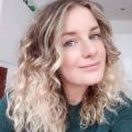 selfie of a woman with creamy blonde balayage curly hair