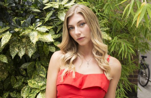 How to curl your hair with a curling wand: Final look of blonde model wearing a red dress