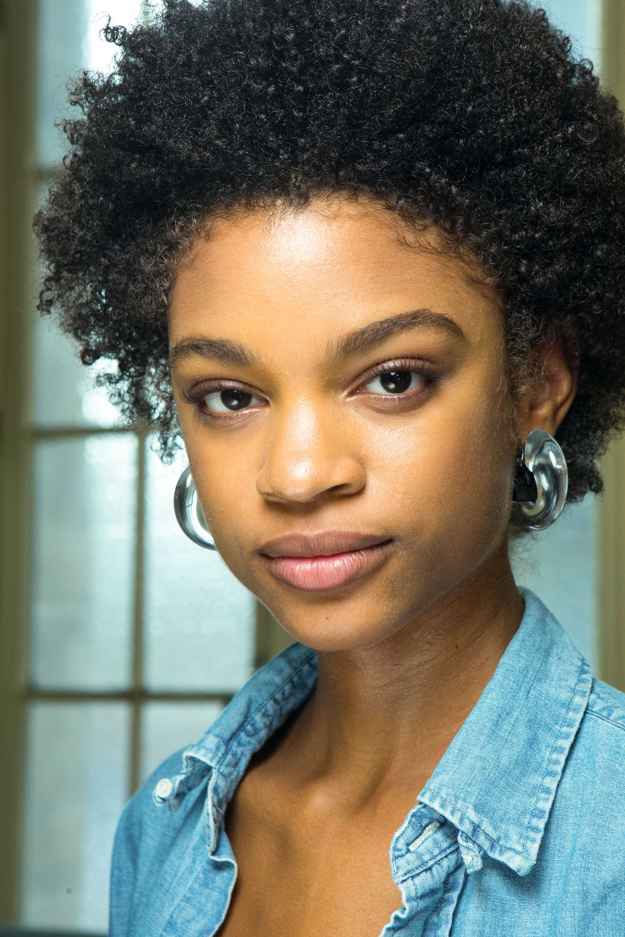 Detangling natural hair guide: Shot of woman with natural curly hair backstage at a show