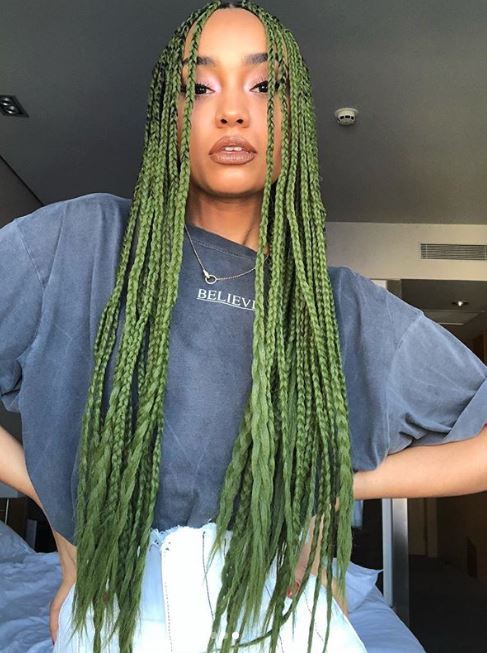 Fall hair colours: Leigh-Anne Pinnock with vivid green long box braids wearing a faded blue top and white bottoms.