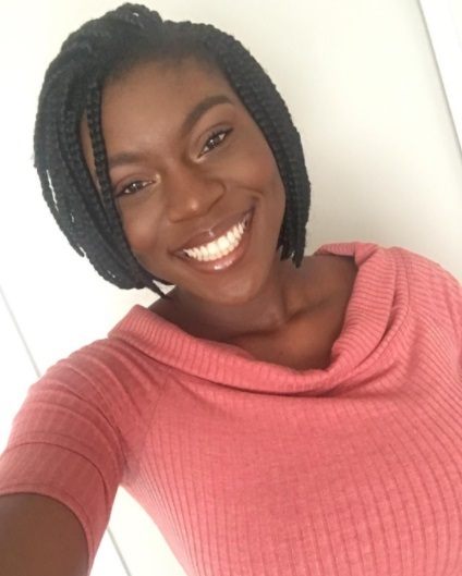 woman wearing a pink cowl neck top with short bob box braids
